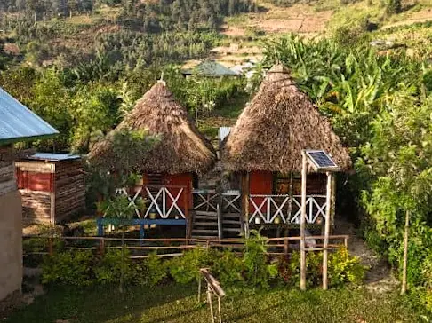 Two thatched cottages on stilts above the hillside