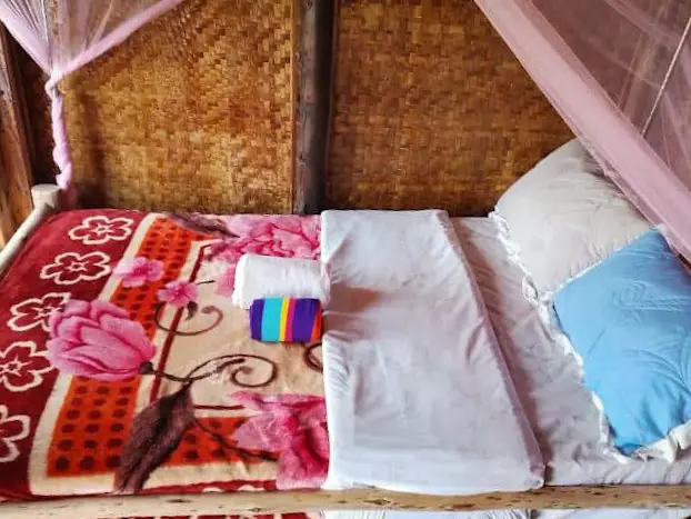 Two beds made up with blankets and folded towels