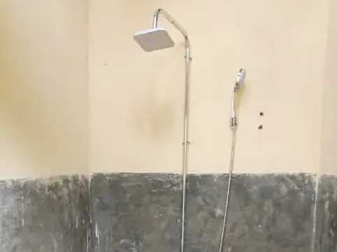 A tiled shower room with a rainfall shower head