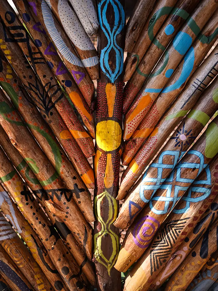 Hand-painted wooden paddles fanned out in bright patterns and colours